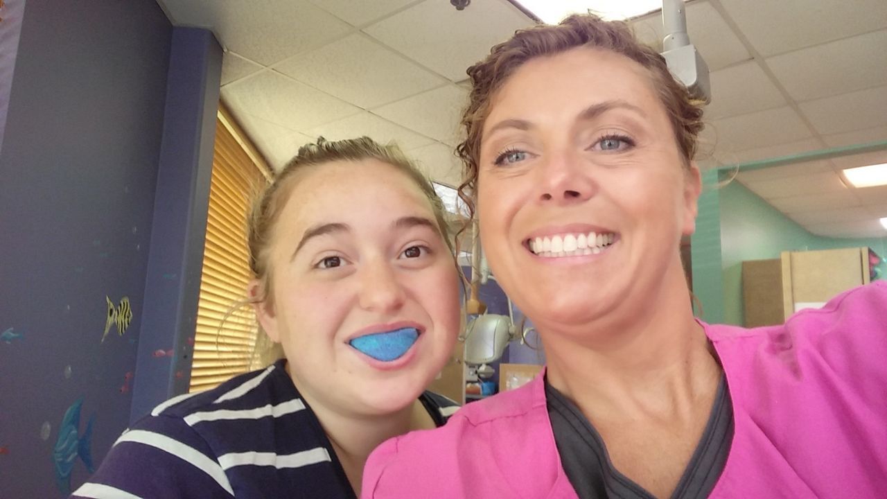 Portrait of smiling mother and daughter in dental office