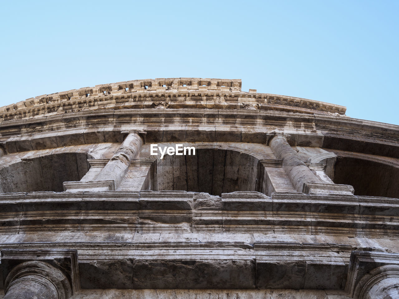 Low angle view of coliseum against clear sky