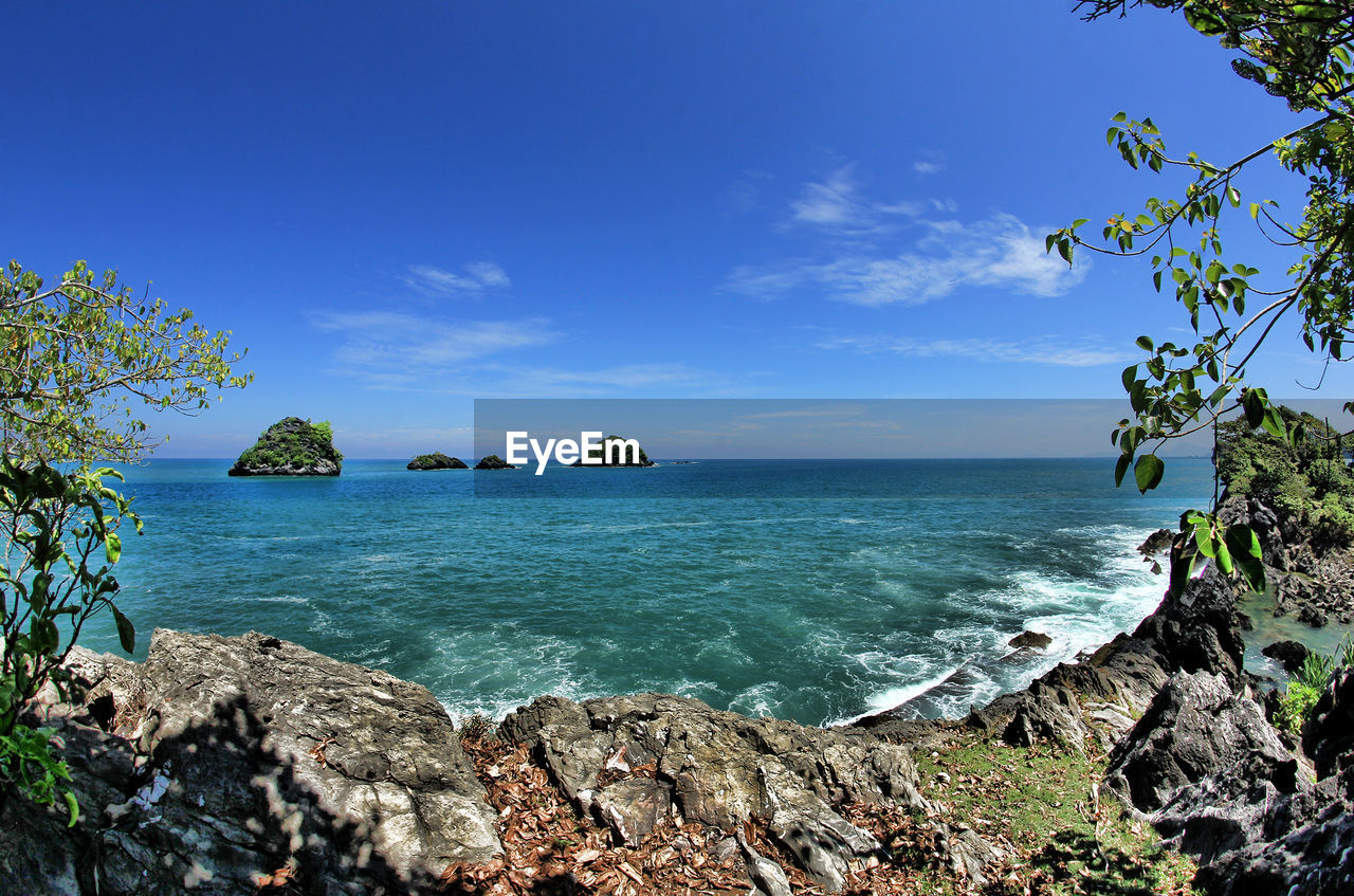 water, sea, sky, land, scenics - nature, beauty in nature, beach, nature, tree, body of water, plant, tranquility, blue, travel destinations, tranquil scene, shore, coast, horizon over water, travel, rock, ocean, environment, horizon, tropical climate, coastline, no people, idyllic, tourism, trip, day, vacation, cloud, outdoors, holiday, landscape, sunlight, island, non-urban scene, seascape, tropics, clear sky, bay, summer, sunny, bay of water, lagoon