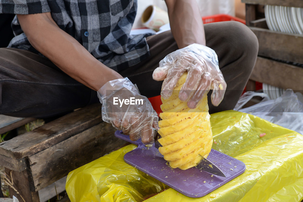food, food and drink, yellow, one person, adult, midsection, occupation, working, indoors, freshness, business finance and industry, dairy, men, sweet food, business, frozen food, holding, hand, ice cream