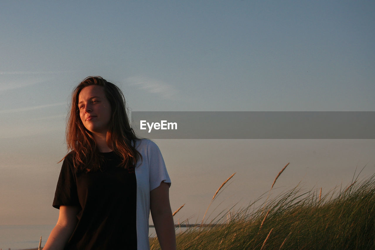 Young woman standing against sky during golden hour