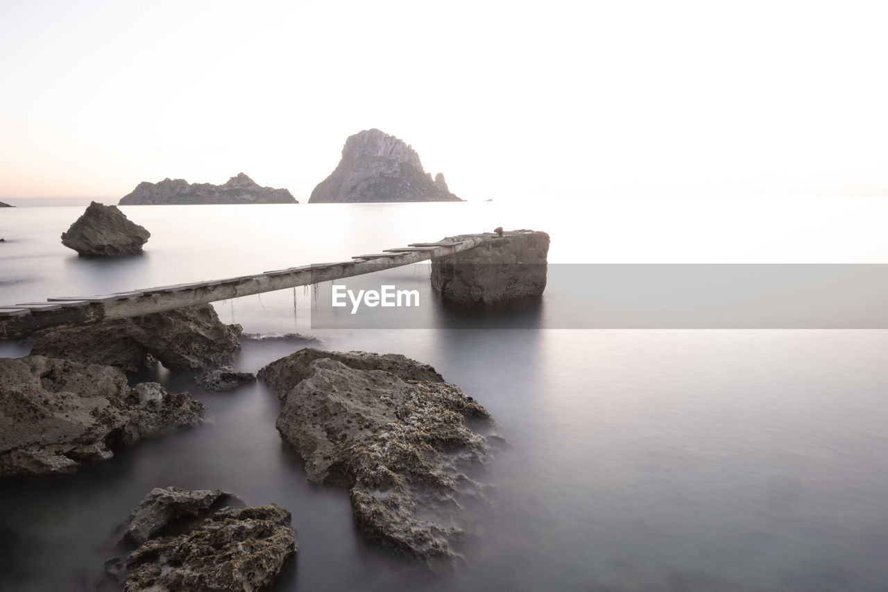 Rock formation in sea against sky