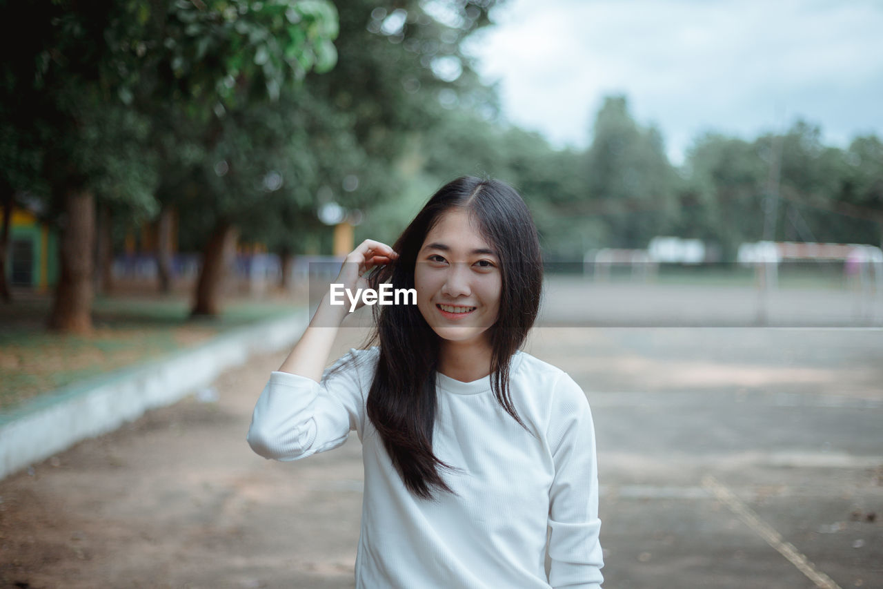 Smiling young woman standing outdoors