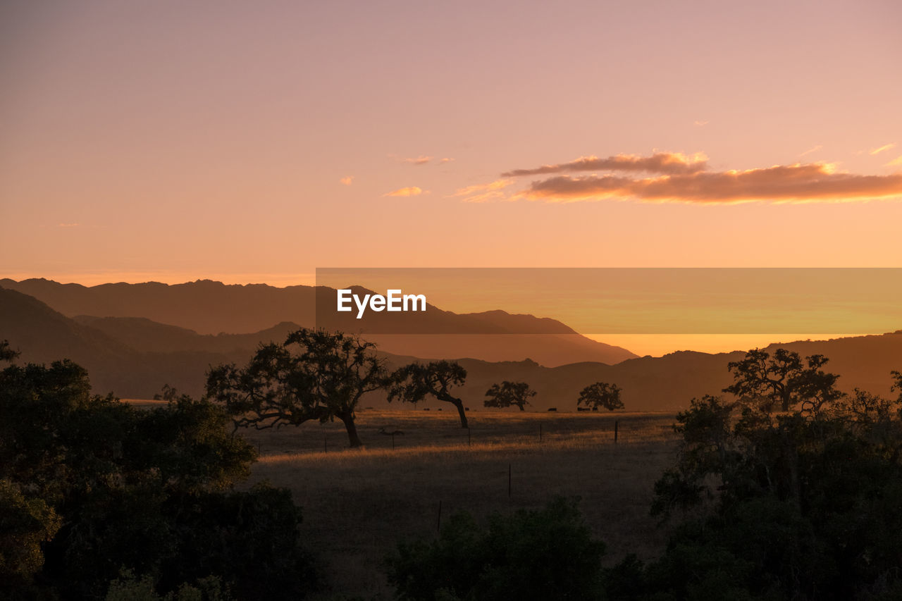 Scenic view of silhouette mountains against sky at sunset