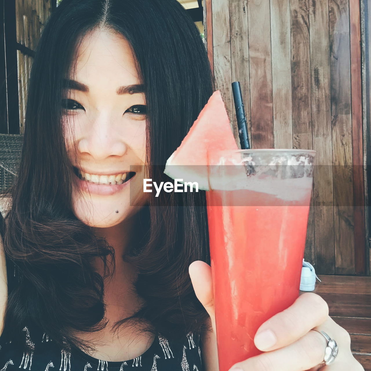 Portrait of smiling woman holding watermelon juice