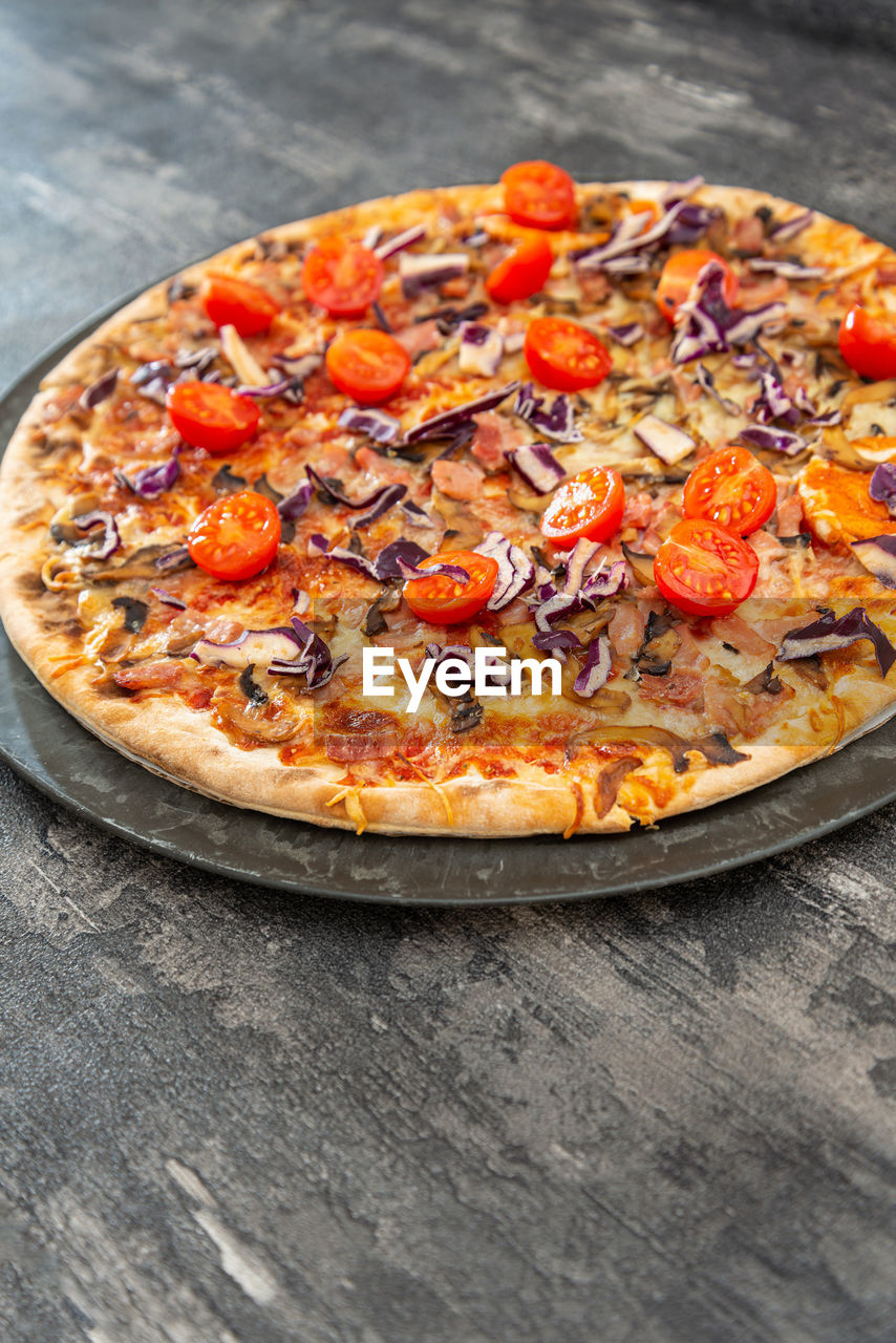 HIGH ANGLE VIEW OF PIZZA IN PLATE ON TABLE