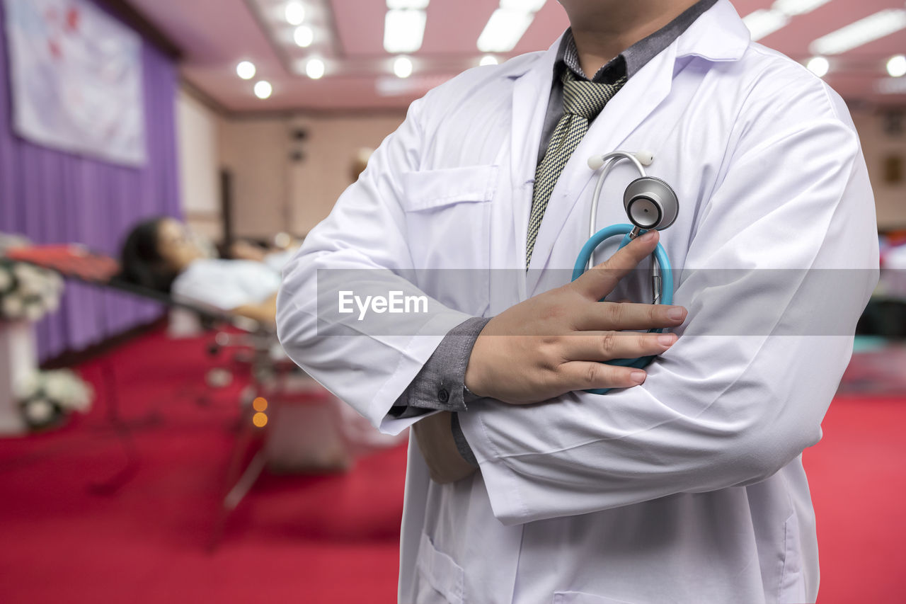 midsection of doctor holding stethoscope at hospital