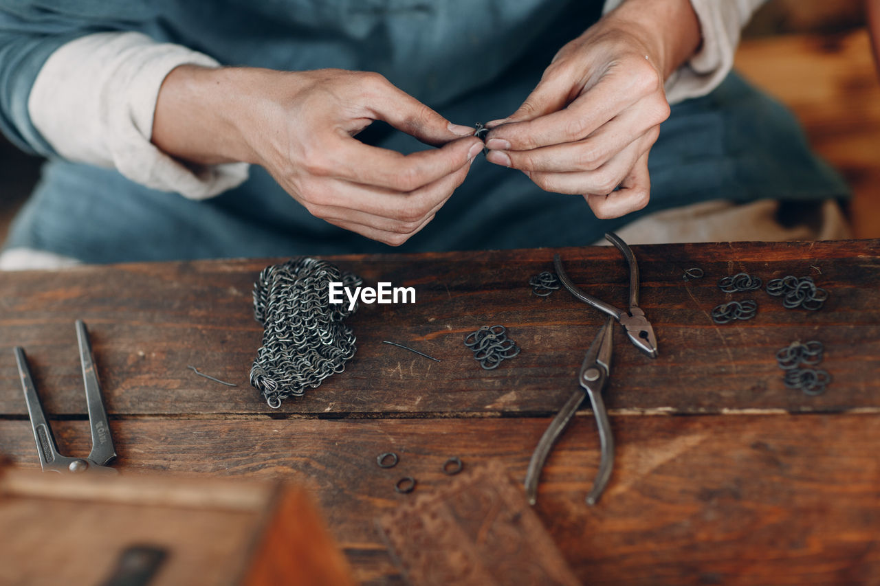 Midsection of man making art and craft product on table