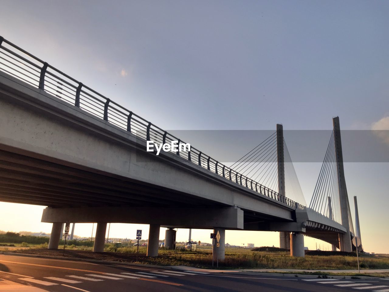 LOW ANGLE VIEW OF BRIDGE AGAINST SKY AT SUNSET