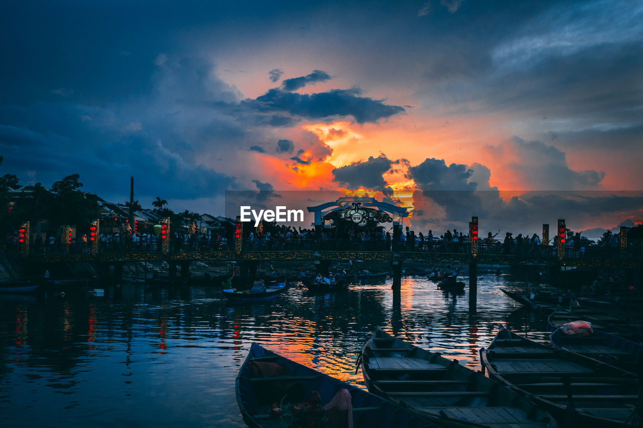 BOATS MOORED IN LAKE AGAINST SKY DURING SUNSET