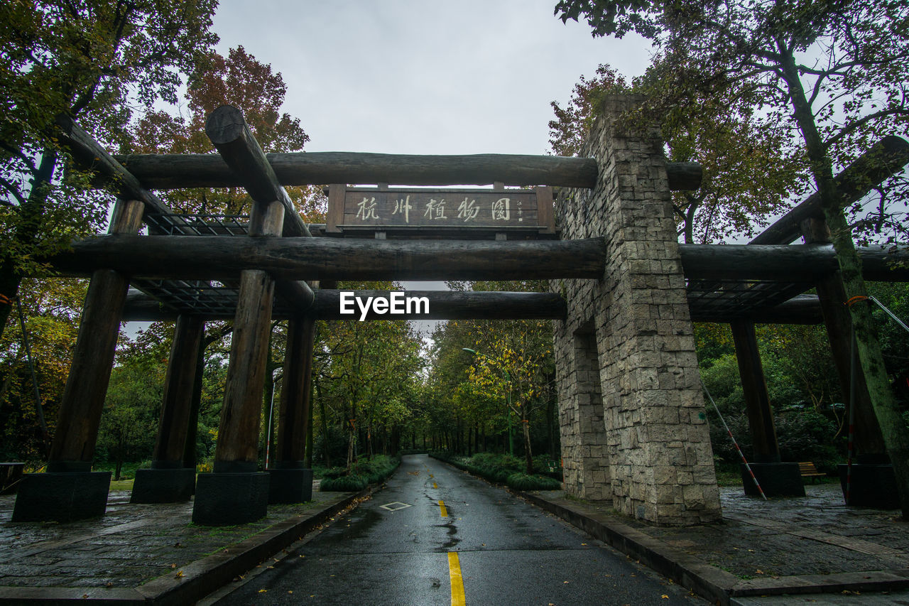 Empty road by bridge against sky