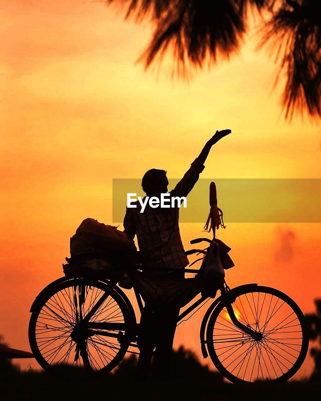 Low angle view of silhouette bicycle against orange sky