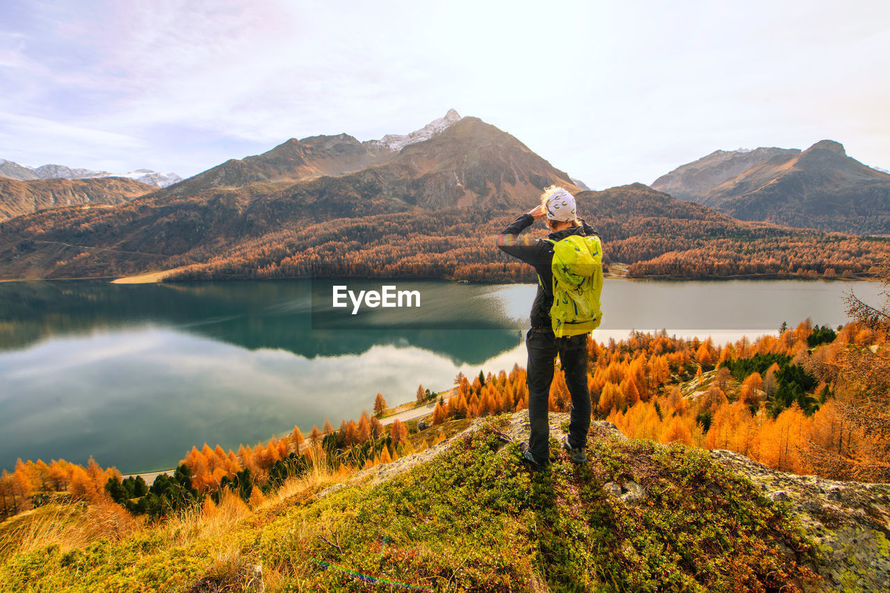 Man observes bewildered autumn landscape in a mountain lake