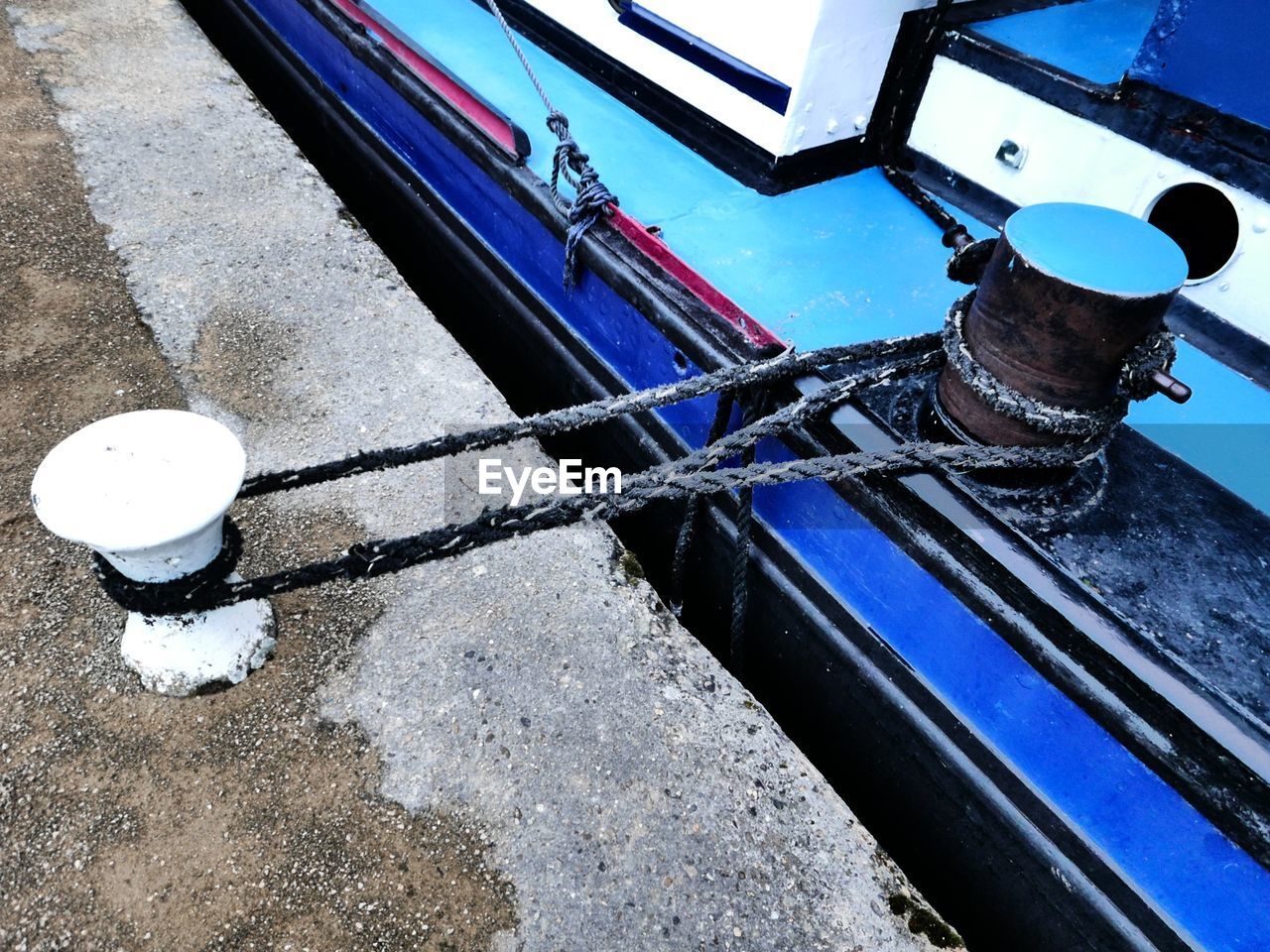 Mooring rope wrapped around cleat on harbor