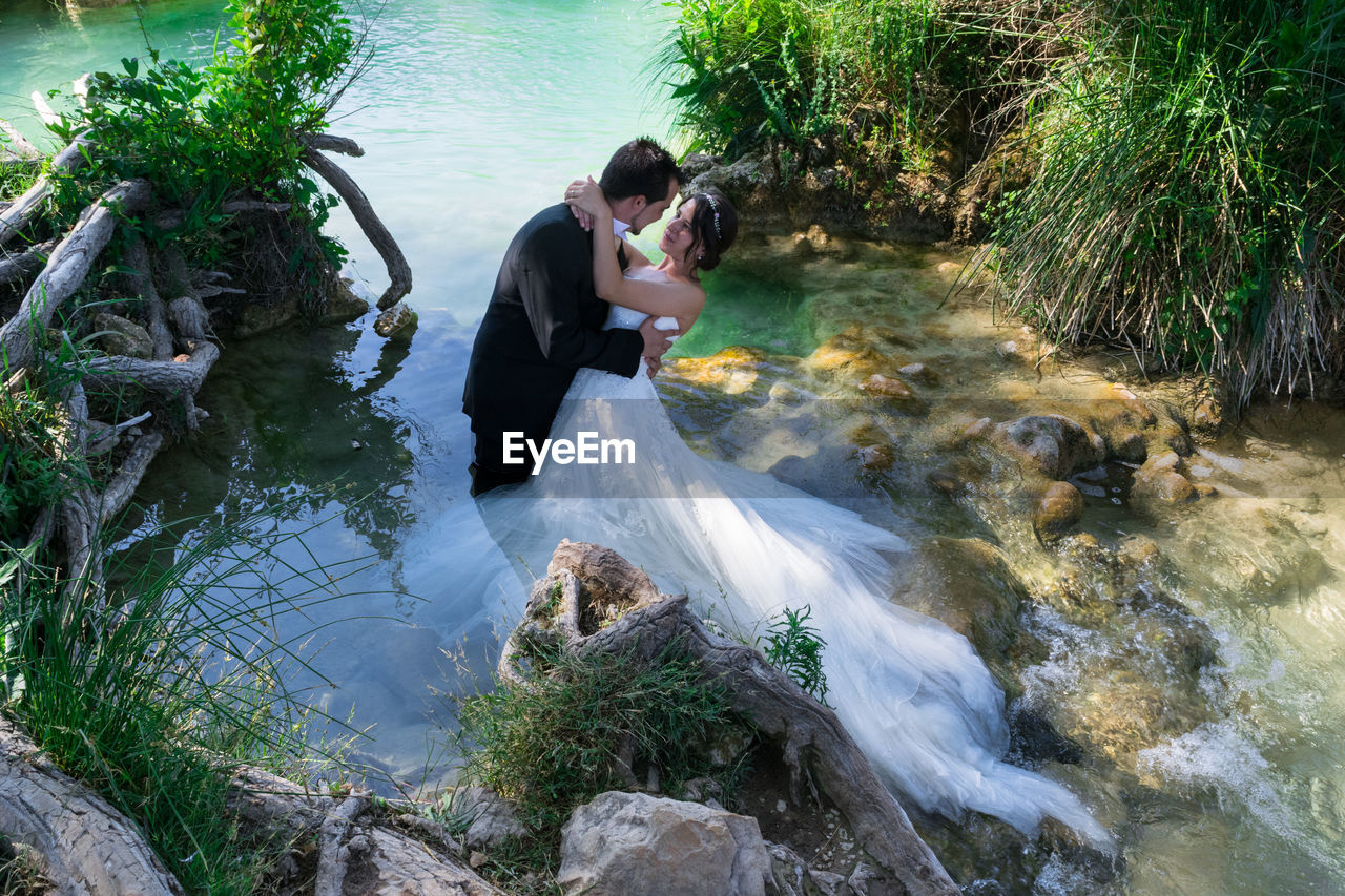 High angle view of wedding couple posing in river