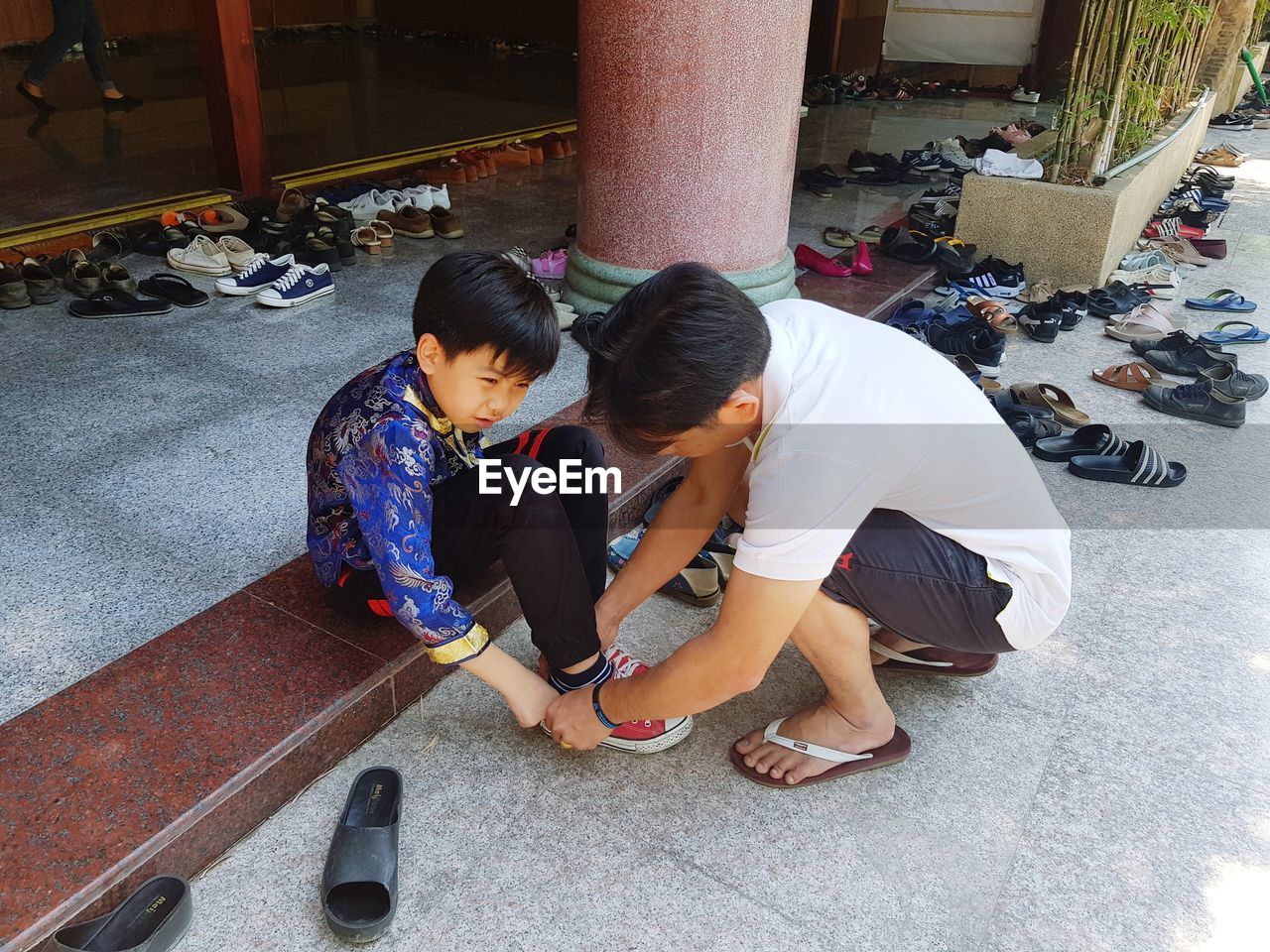 HIGH ANGLE VIEW OF MOTHER AND DAUGHTER SITTING ON FLOOR