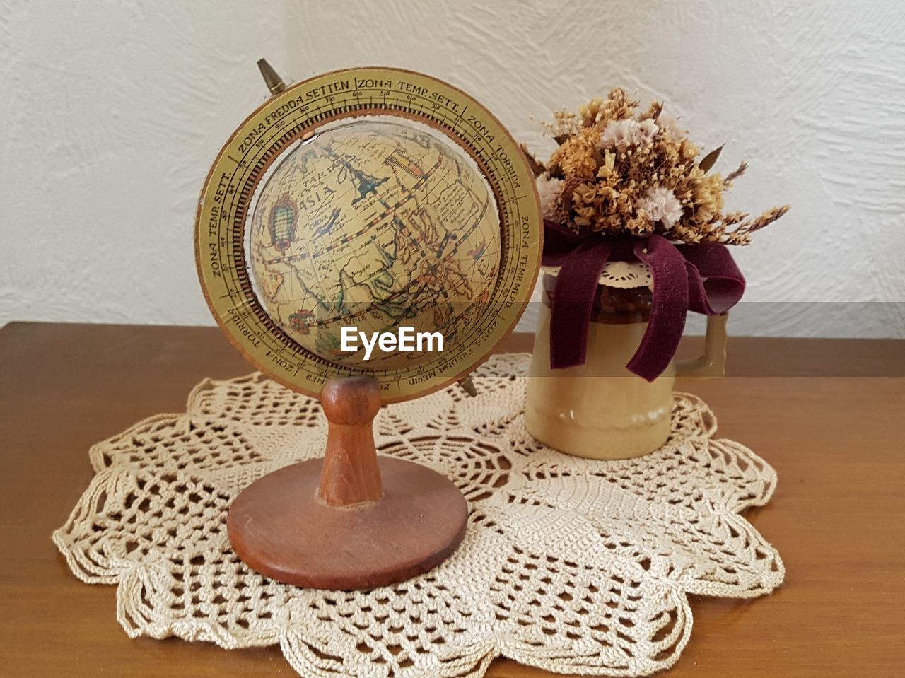 High angle view of globe by flower in vase on table