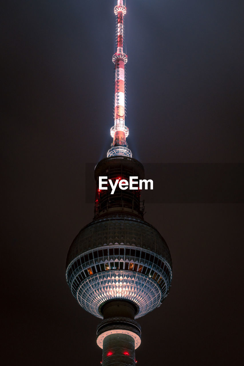 Low angle view of illuminated tower against sky at night