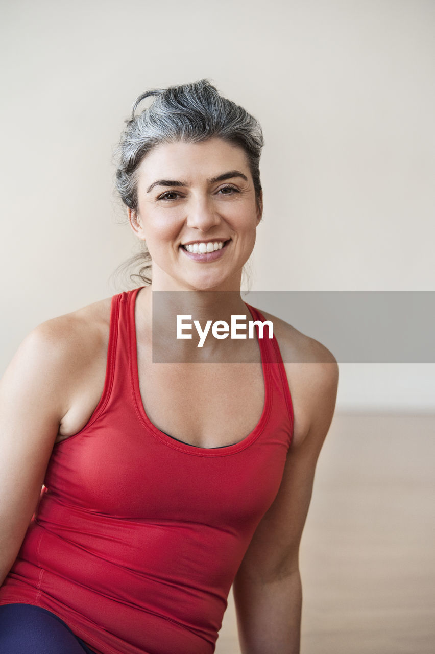 Portrait of happy woman performing yoga in gym