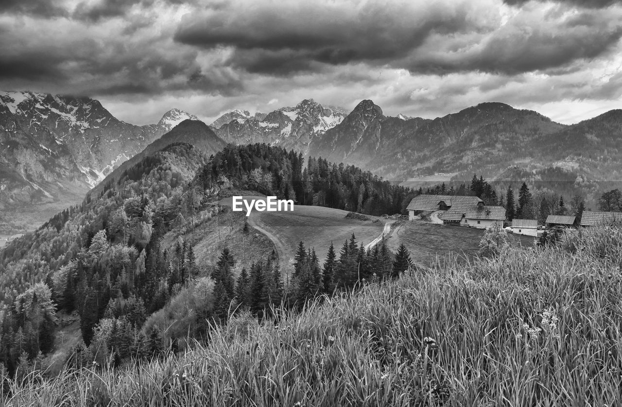 mountain, environment, landscape, scenics - nature, plant, black and white, cloud, beauty in nature, sky, land, nature, mountain range, monochrome, monochrome photography, no people, snow, tree, tranquility, architecture, grass, tranquil scene, field, rural scene, wilderness, building, non-urban scene, outdoors, built structure, house, day, travel destinations, travel, building exterior, valley, panoramic