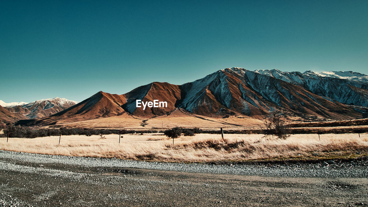 Scenic view of snowcapped mountains against clear blue sky