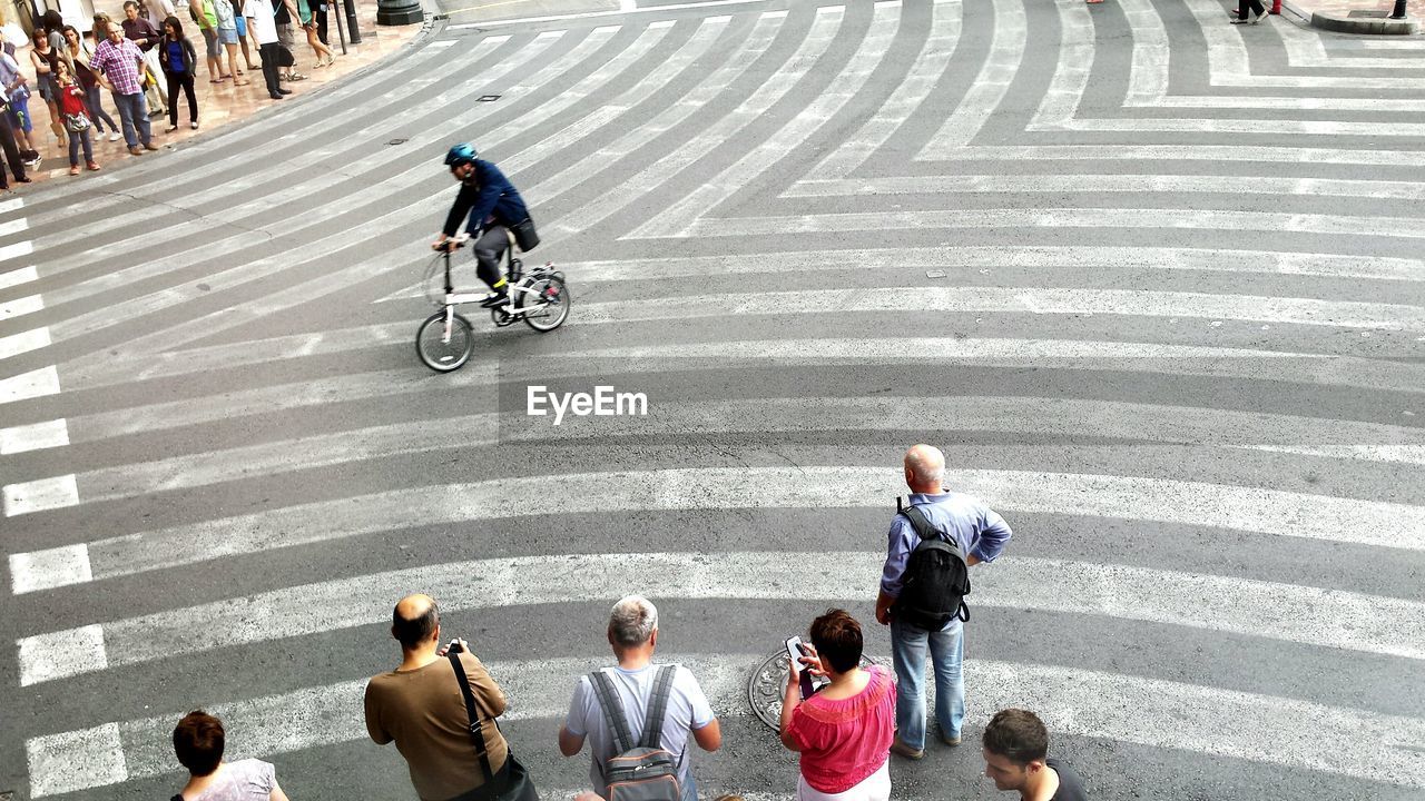 High angle view of cyclist on road amidst people