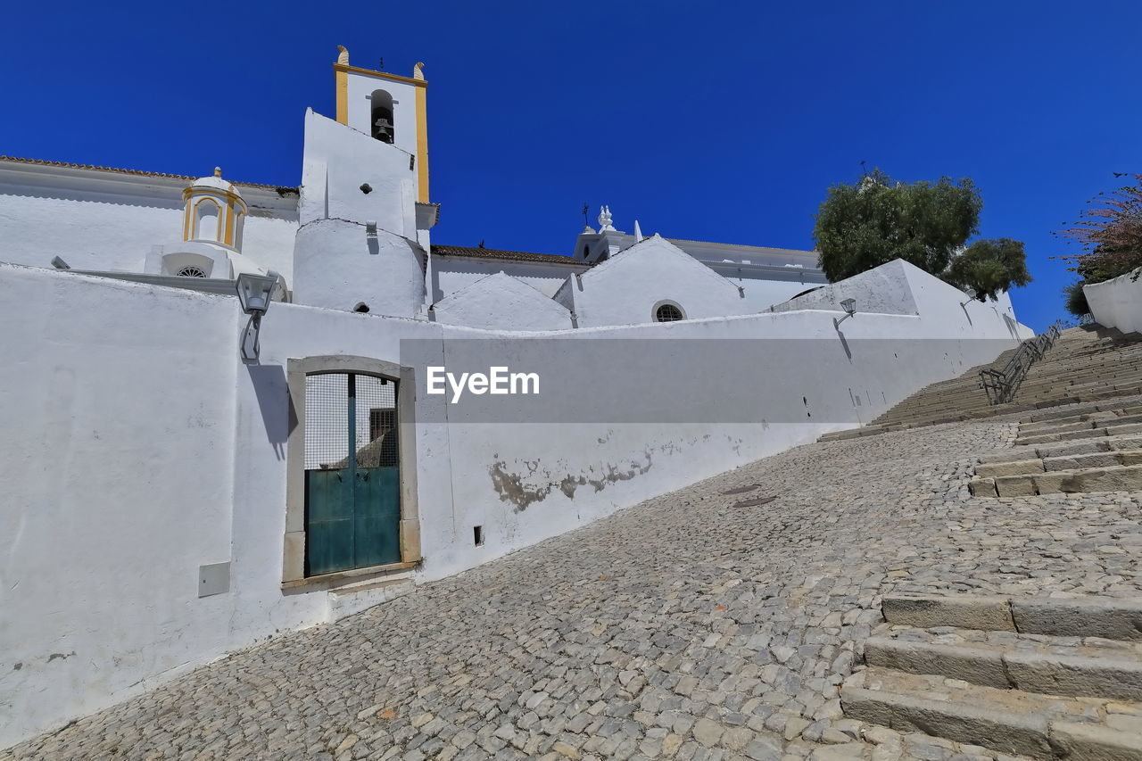 architecture, built structure, building exterior, blue, sky, religion, building, nature, wall, place of worship, clear sky, belief, travel destinations, history, no people, spirituality, the past, day, travel, outdoors, white, sunny, tourism, land, sunlight