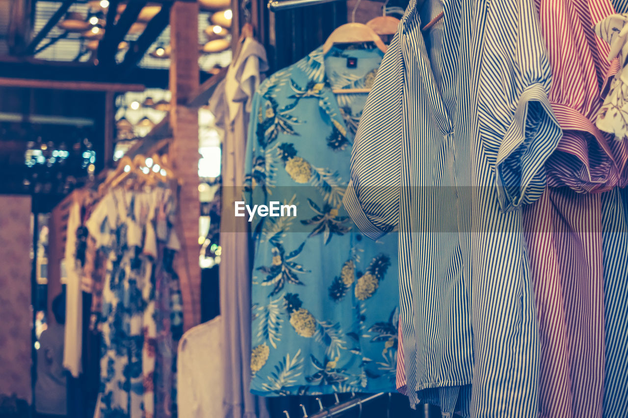 View of various clothes hanging for sale at market