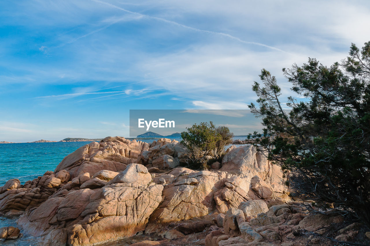 Rock formations by sea against sky