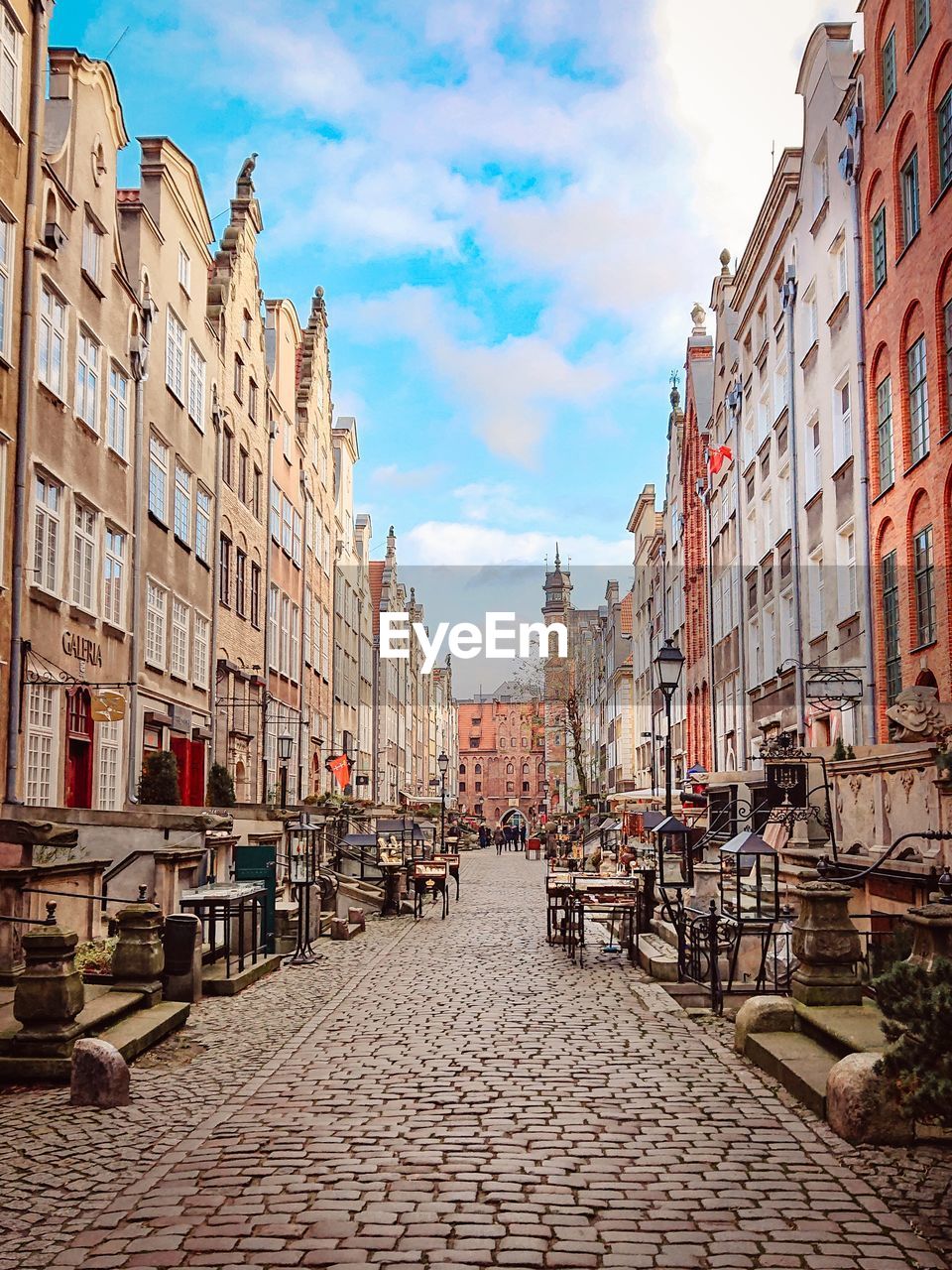 VIEW OF STREET AMIDST BUILDINGS AGAINST SKY