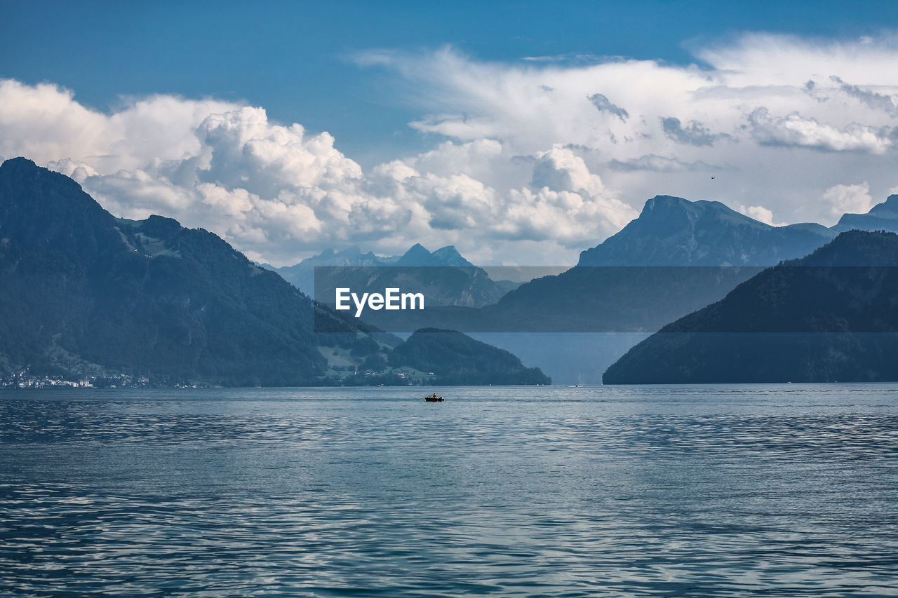 Scenic view of sea and mountains against sky