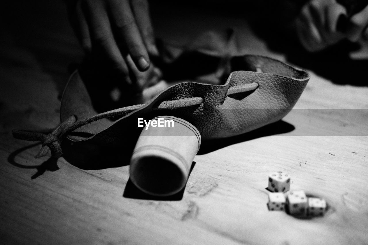 Cropped image of hand reaching for dice on table