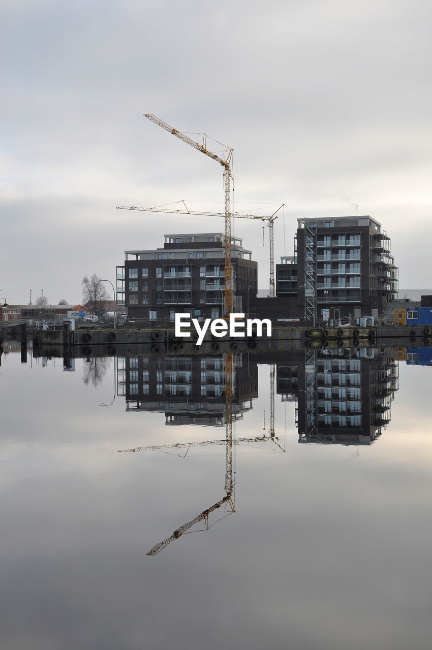 water, architecture, sky, built structure, reflection, crane - construction machinery, industry, building exterior, vehicle, construction industry, cloud, nature, building, machinery, city, business, construction site, business finance and industry, no people, development, outdoors, day, sea