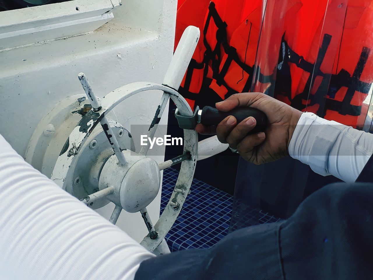 Cropped hand holding steering wheel in boat