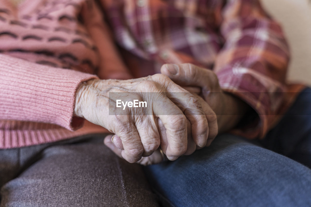 Mature man holding hands of senior woman at home