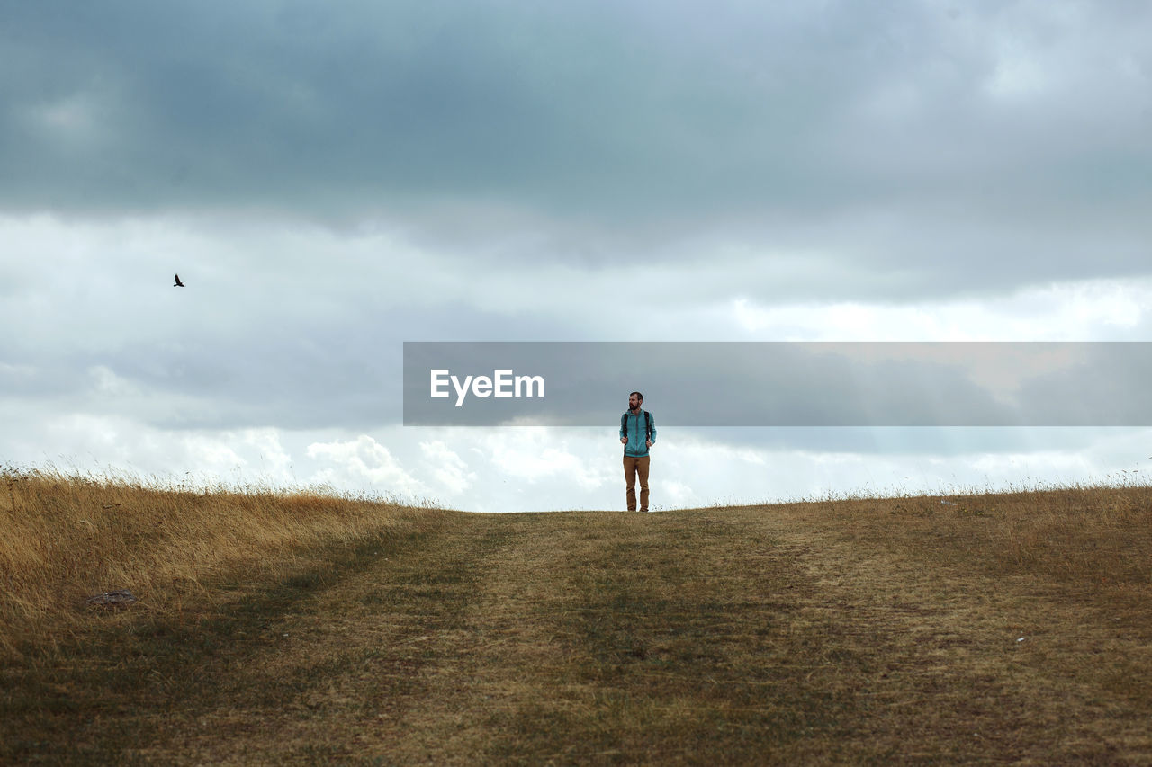 Man standing on field against sky