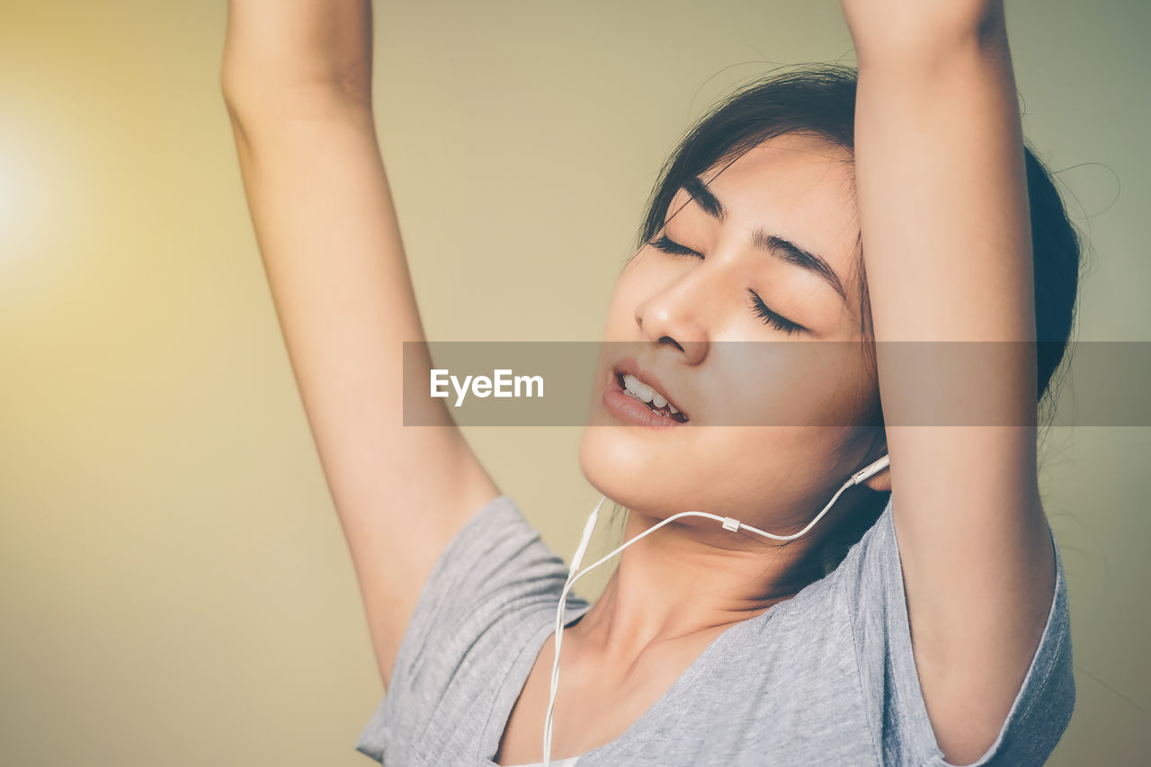 Side view of woman listening music at home