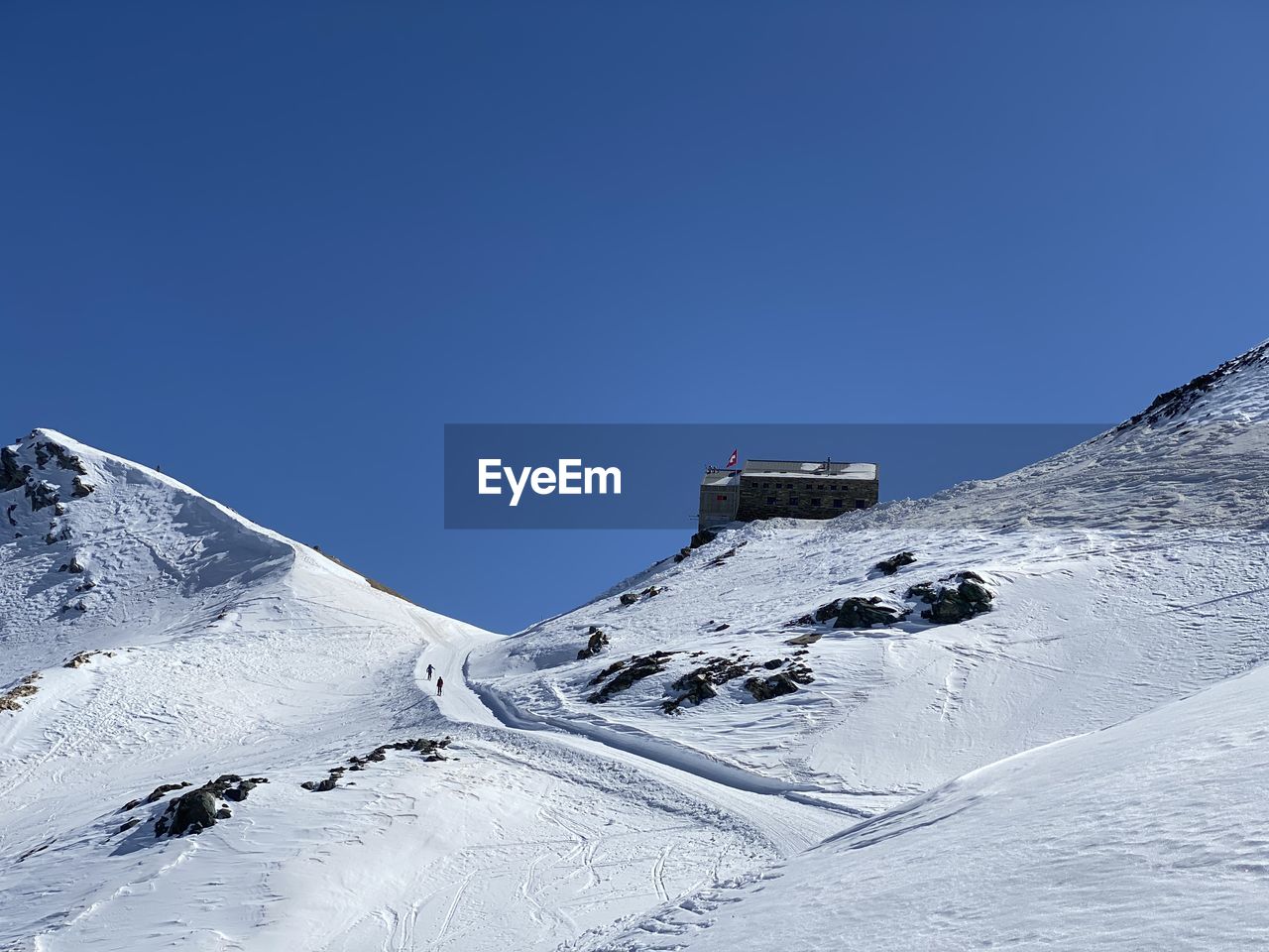 Snow covered mountain against clear blue sky