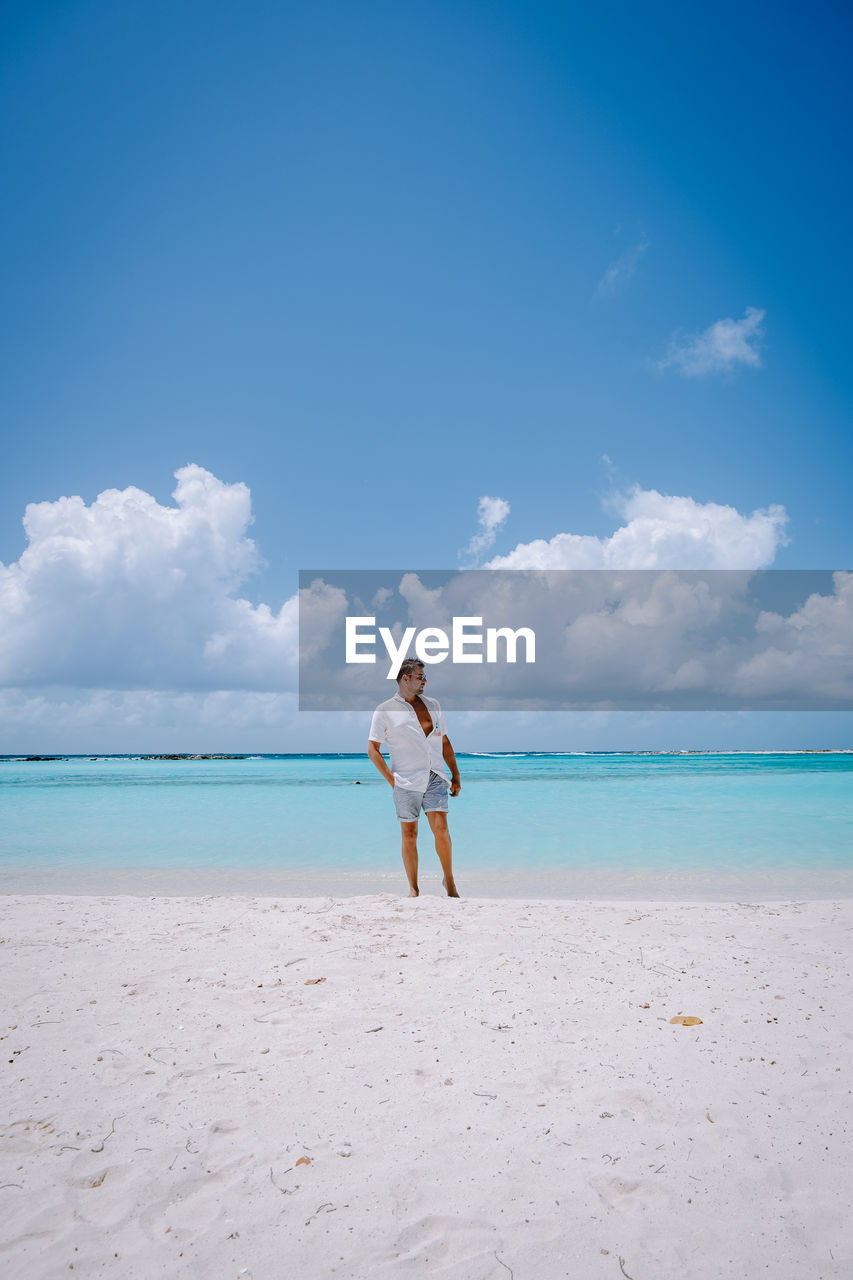 FULL LENGTH OF MAN STANDING ON BEACH