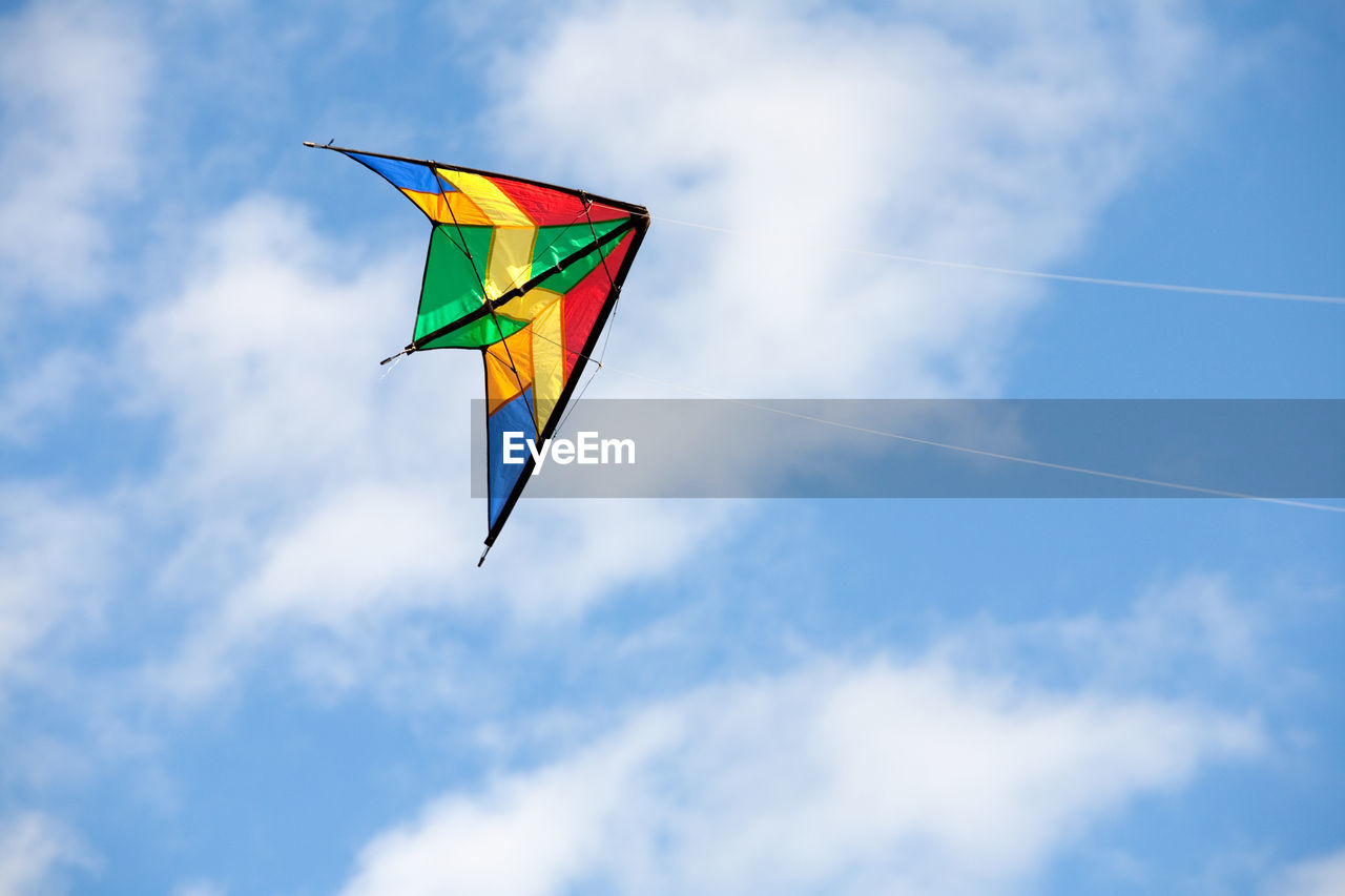 LOW ANGLE VIEW OF FLAG FLYING AGAINST BLUE SKY