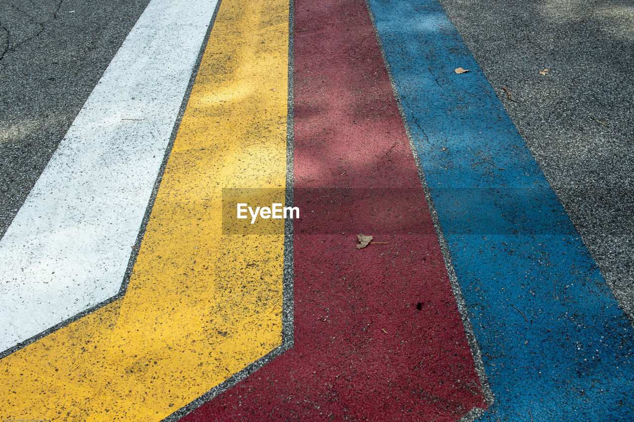 HIGH ANGLE VIEW OF YELLOW ROAD MARKING ON STREET