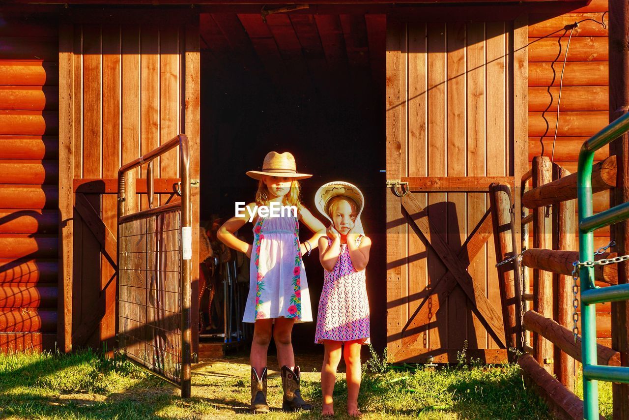 Portrait of girls standing against built structure