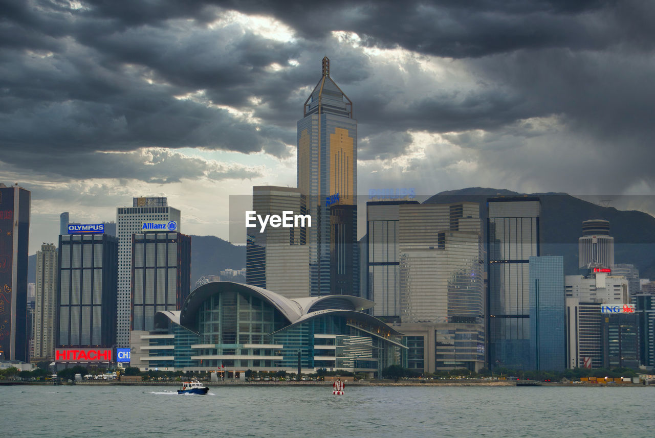BUILDINGS BY RIVER AGAINST SKY