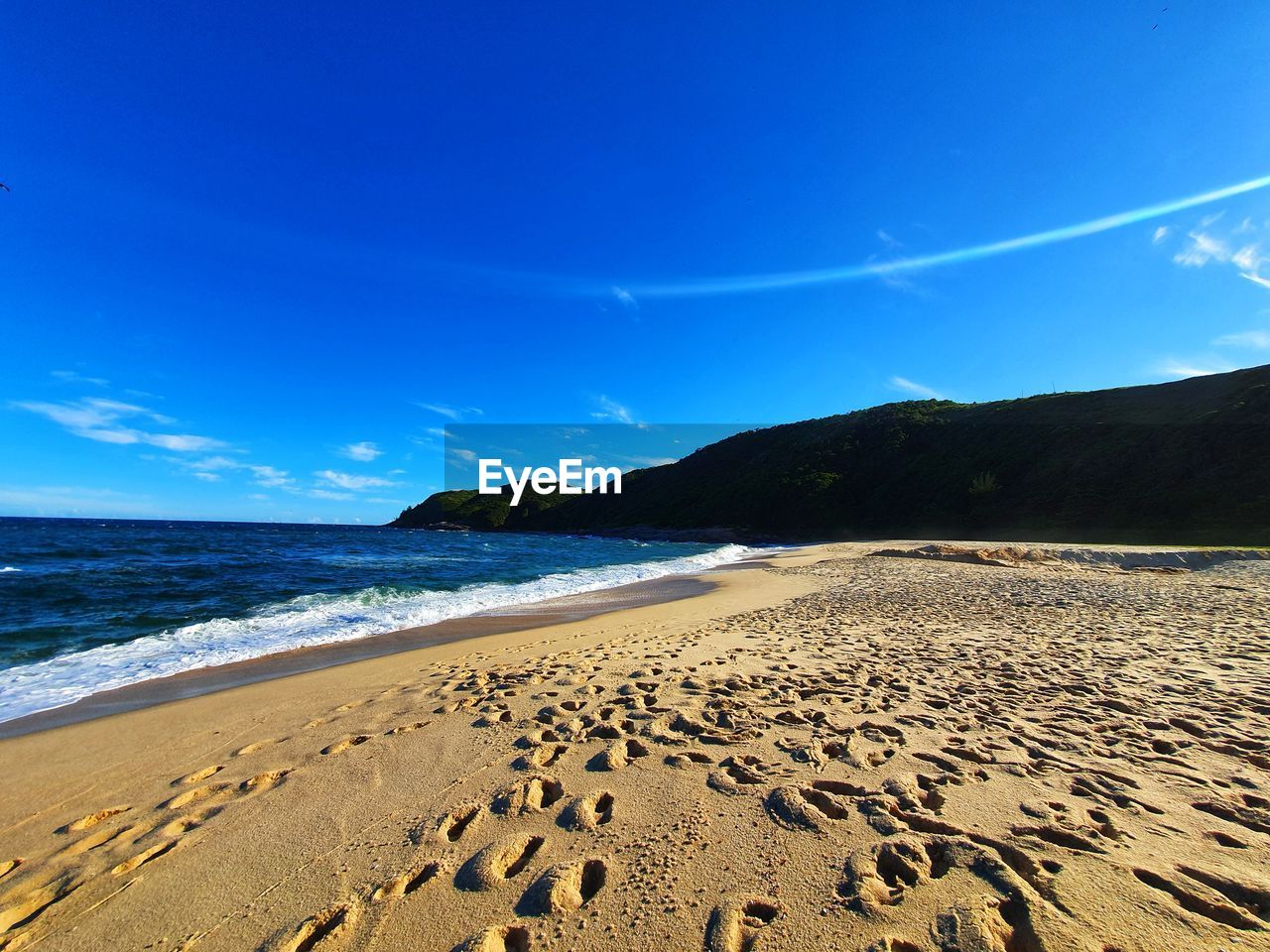 Scenic view of beach against blue sky