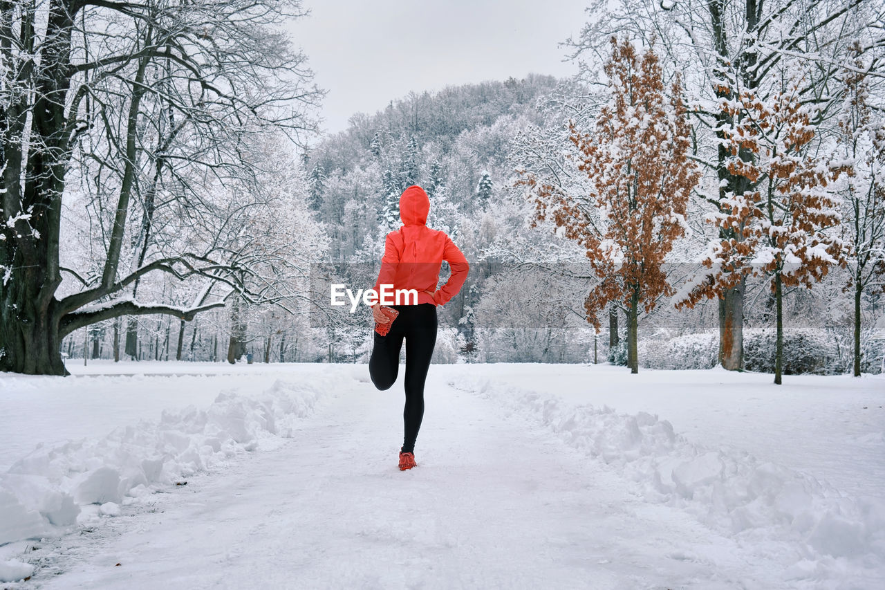 Running woman, girl runner on snow in park winter day. run, sport concept, leisure and freedom.