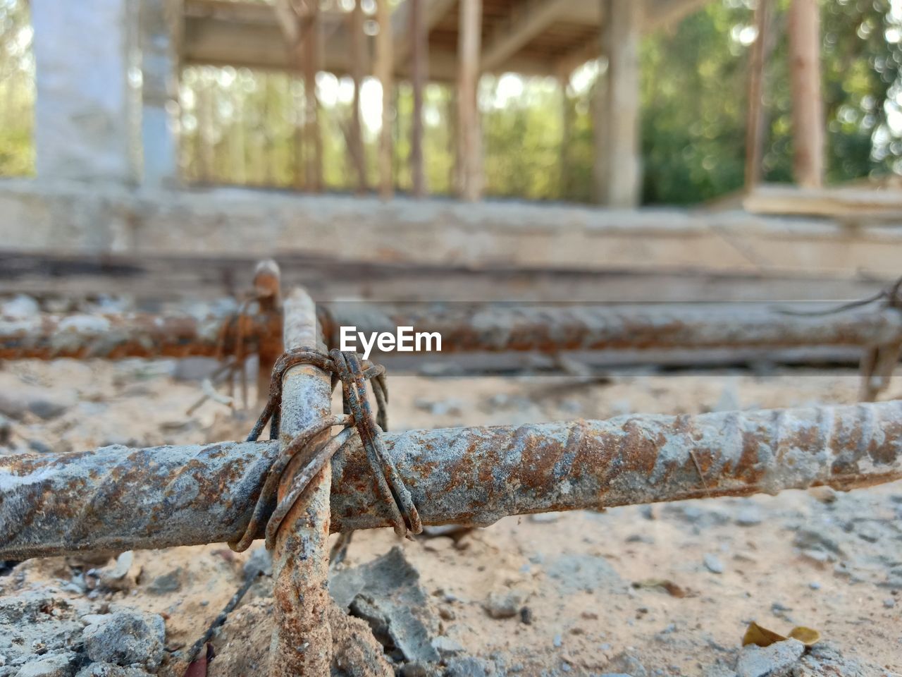 CLOSE-UP OF ROPE TIED TO RUSTY METAL FENCE