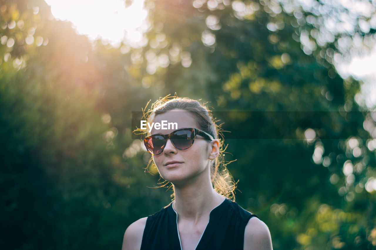 PORTRAIT OF YOUNG WOMAN AGAINST SUNGLASSES