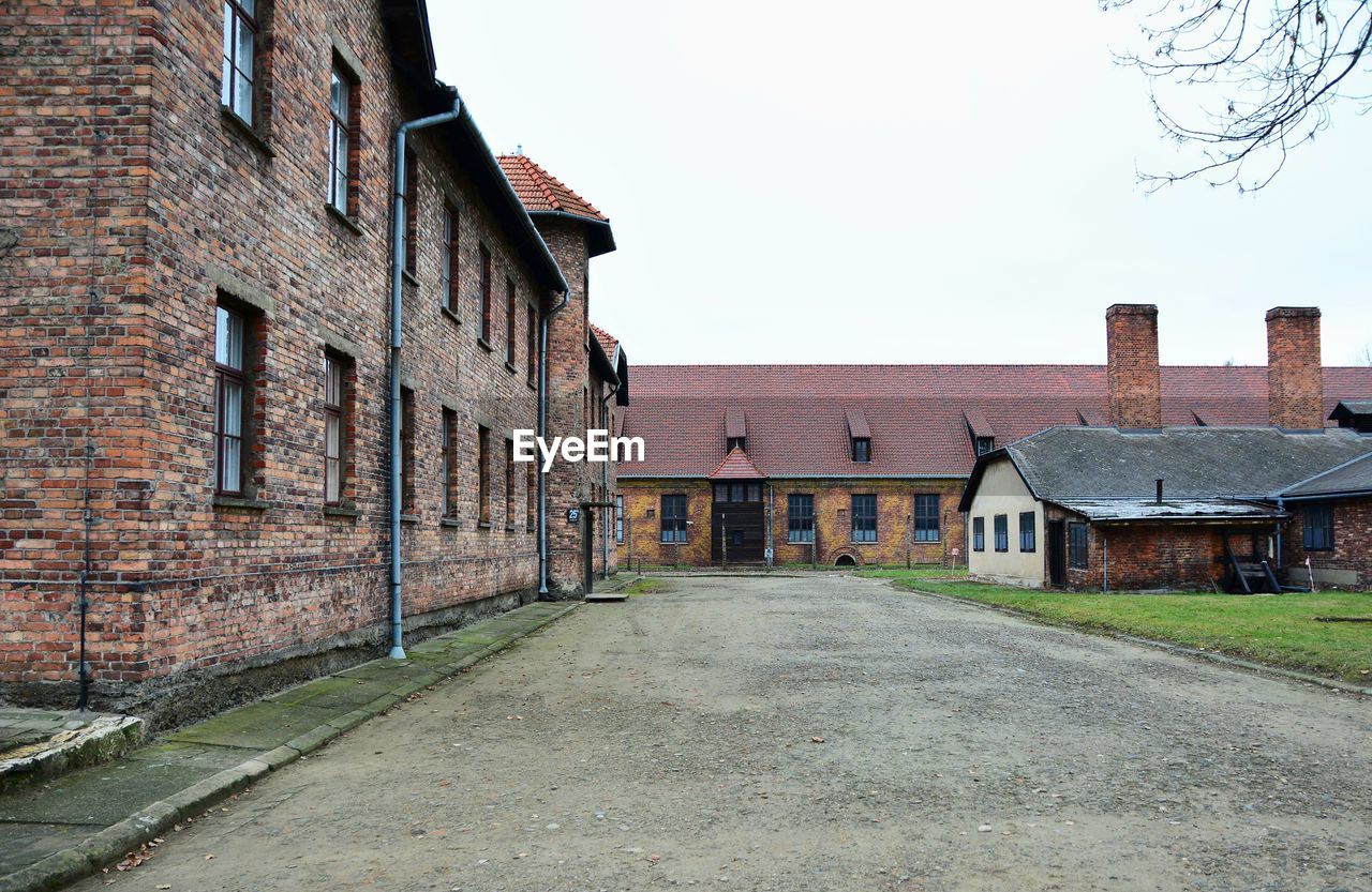 STREET AMIDST OLD BUILDINGS AGAINST SKY