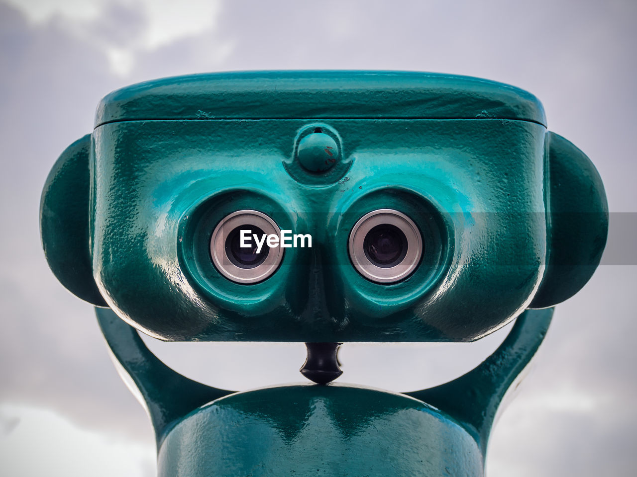 Close-up of coin-operated binoculars against cloudy sky