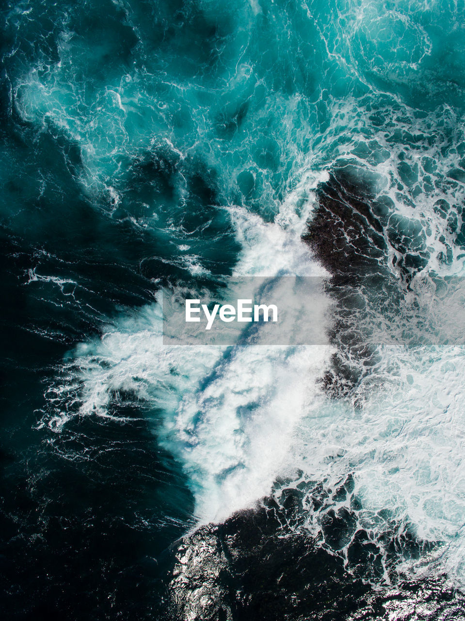 High angle view of waves splashing on rocks